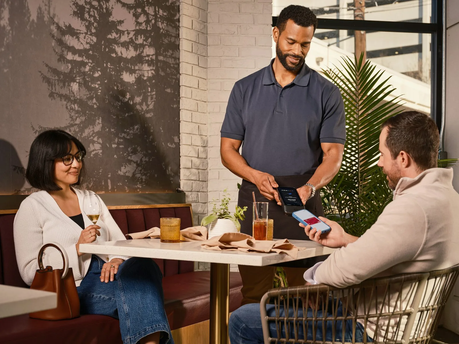 Waiter bringing the card machine to the table so the customer can pay by card