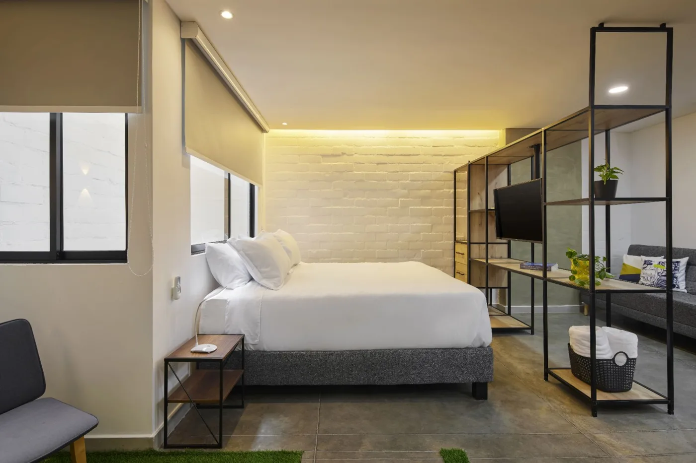 Suite Deluxe con cama frente a un muro de ladrillo iluminado