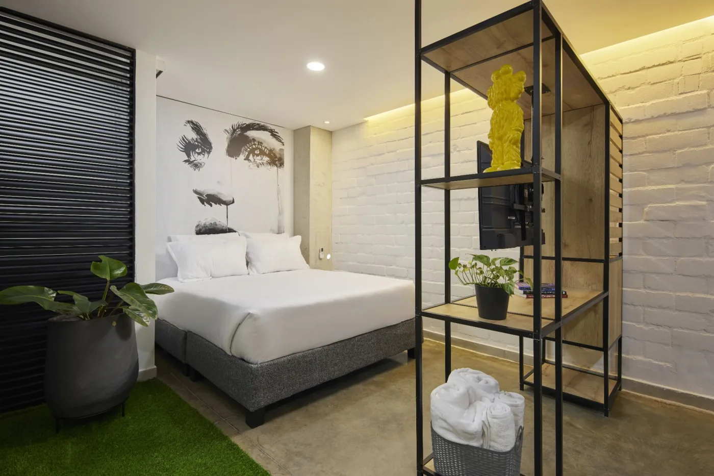 Suite Estándar con cama, estantería metálica y piso de césped artificial