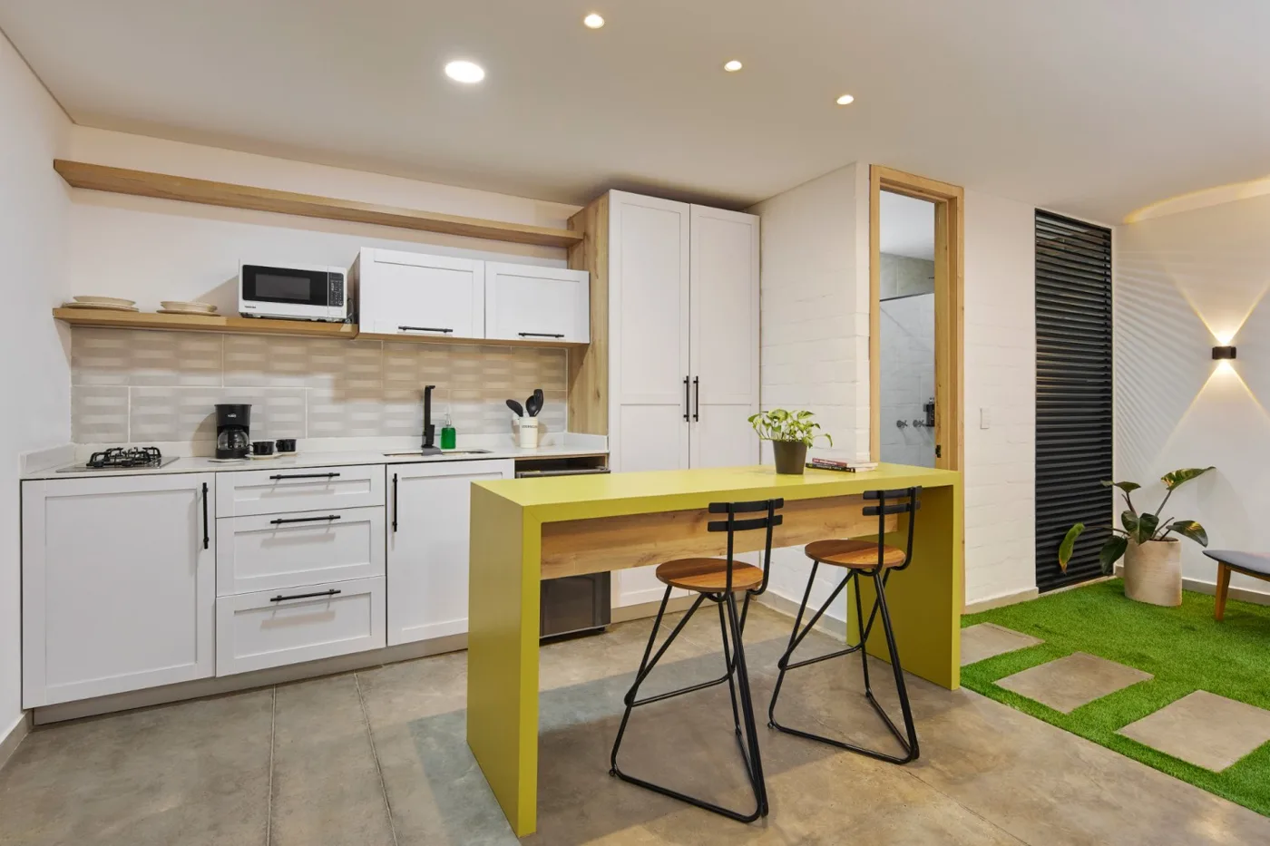 Cocina dotada con barra verde y taburetes
