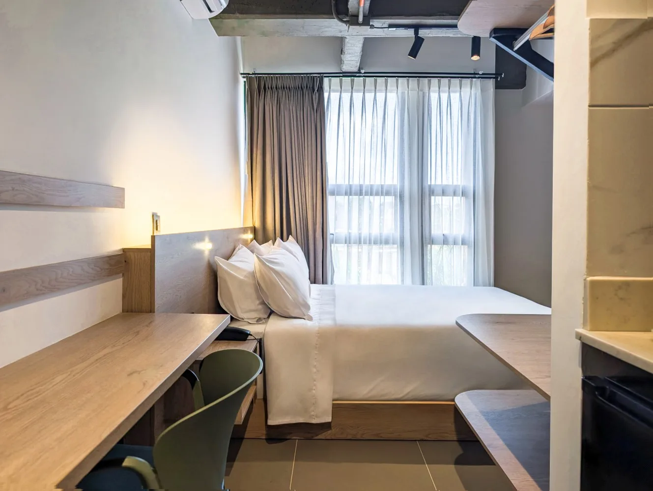 Habitación Deluxe con cama queen, escritorio de madera y ventanal