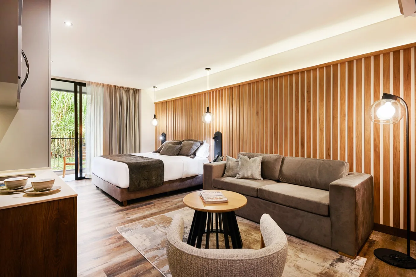 Suite con Balcón: cama king, sofá, mesa redonda y puerta al balcón