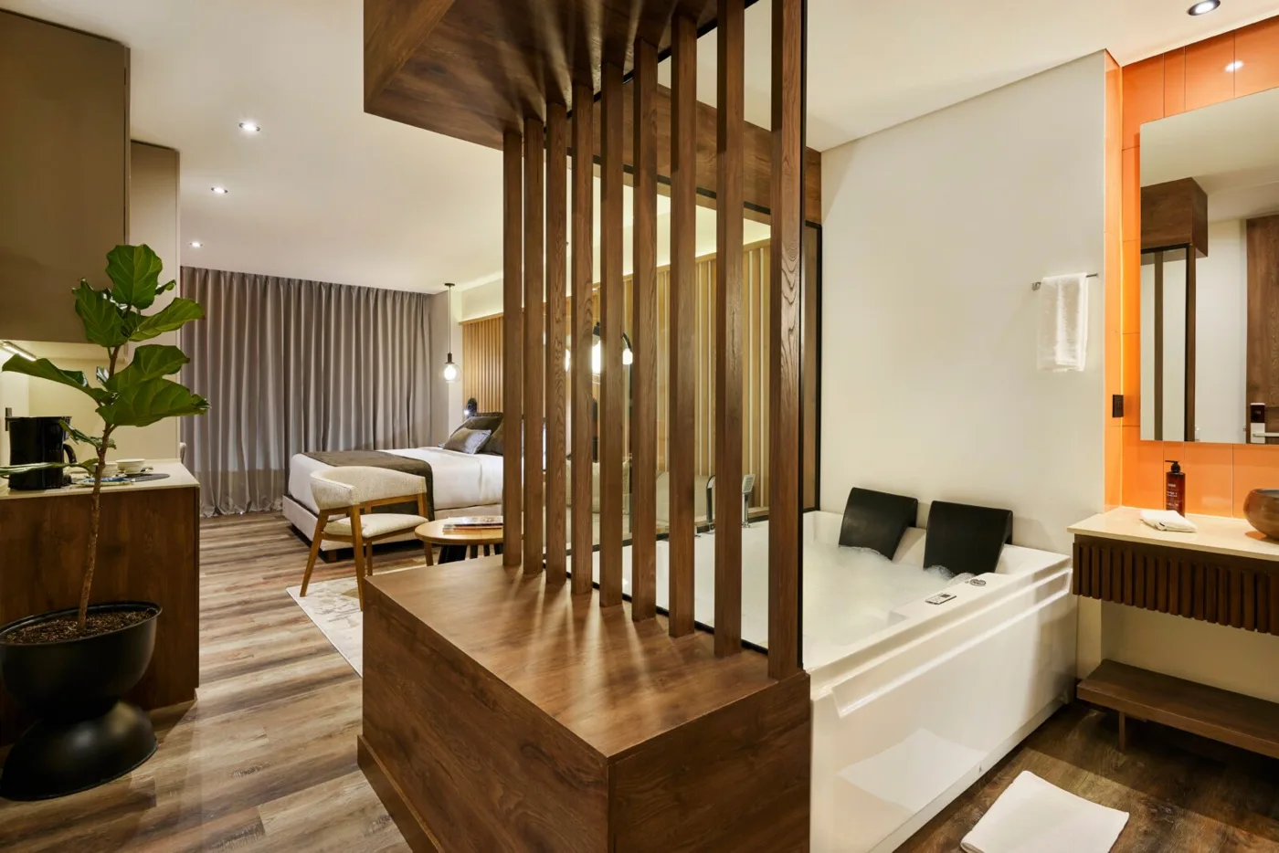 Suite Exclusiva con jacuzzi detrás de una celosía de madera y la cama al fondo