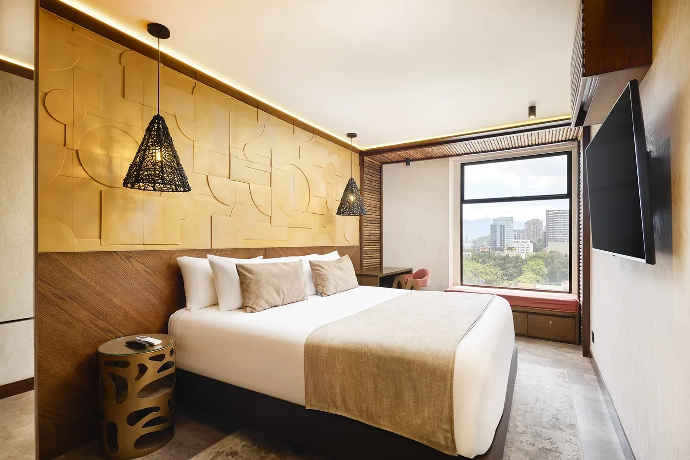 Suite Superior con cama king, mural dorado y ventana con vista a la ciudad
