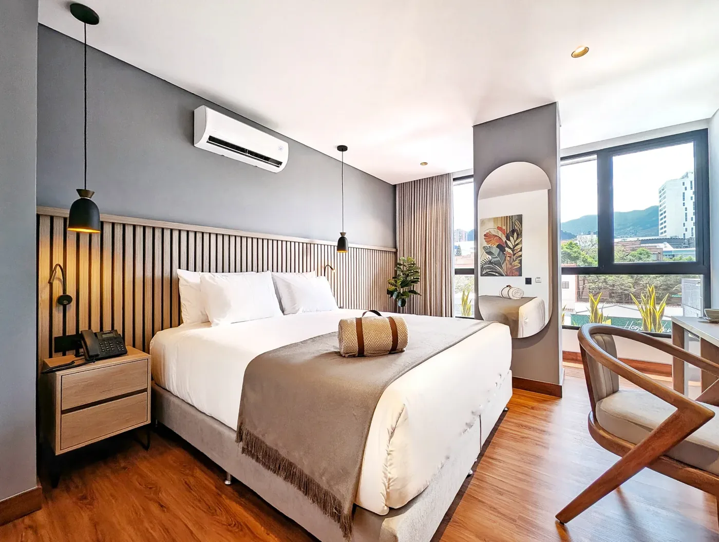 Suite Deluxe con cama king, ventanal en esquina y butaca de madera