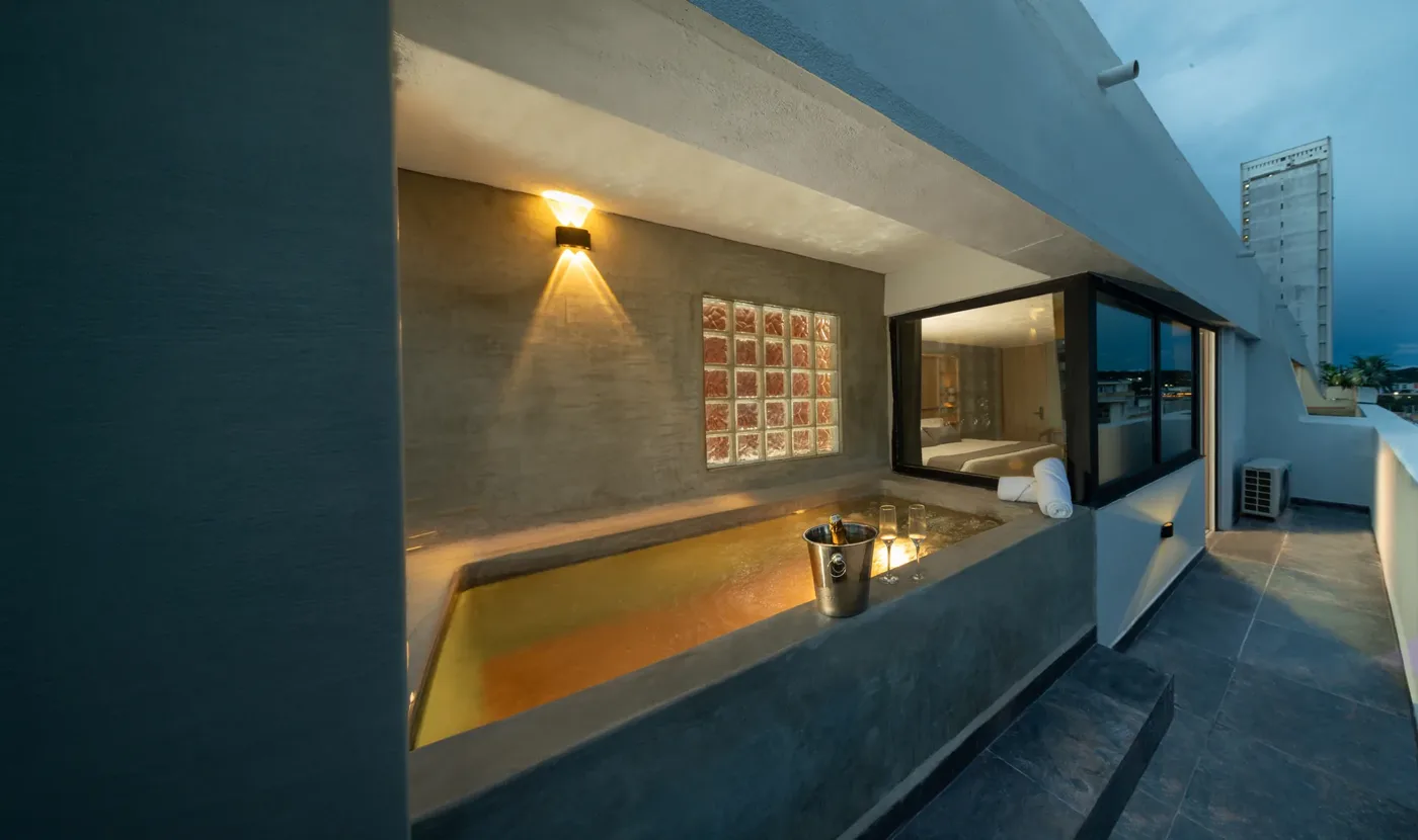 Terraza de la Suite con Piscina Privada al atardecer, con la piscina iluminada