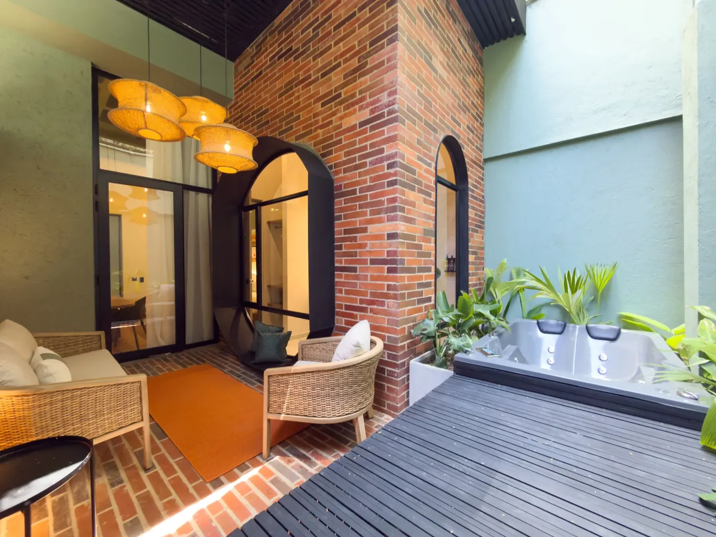 Patio privado de la Suite Exclusiva con deck de madera, plantas y jacuzzi