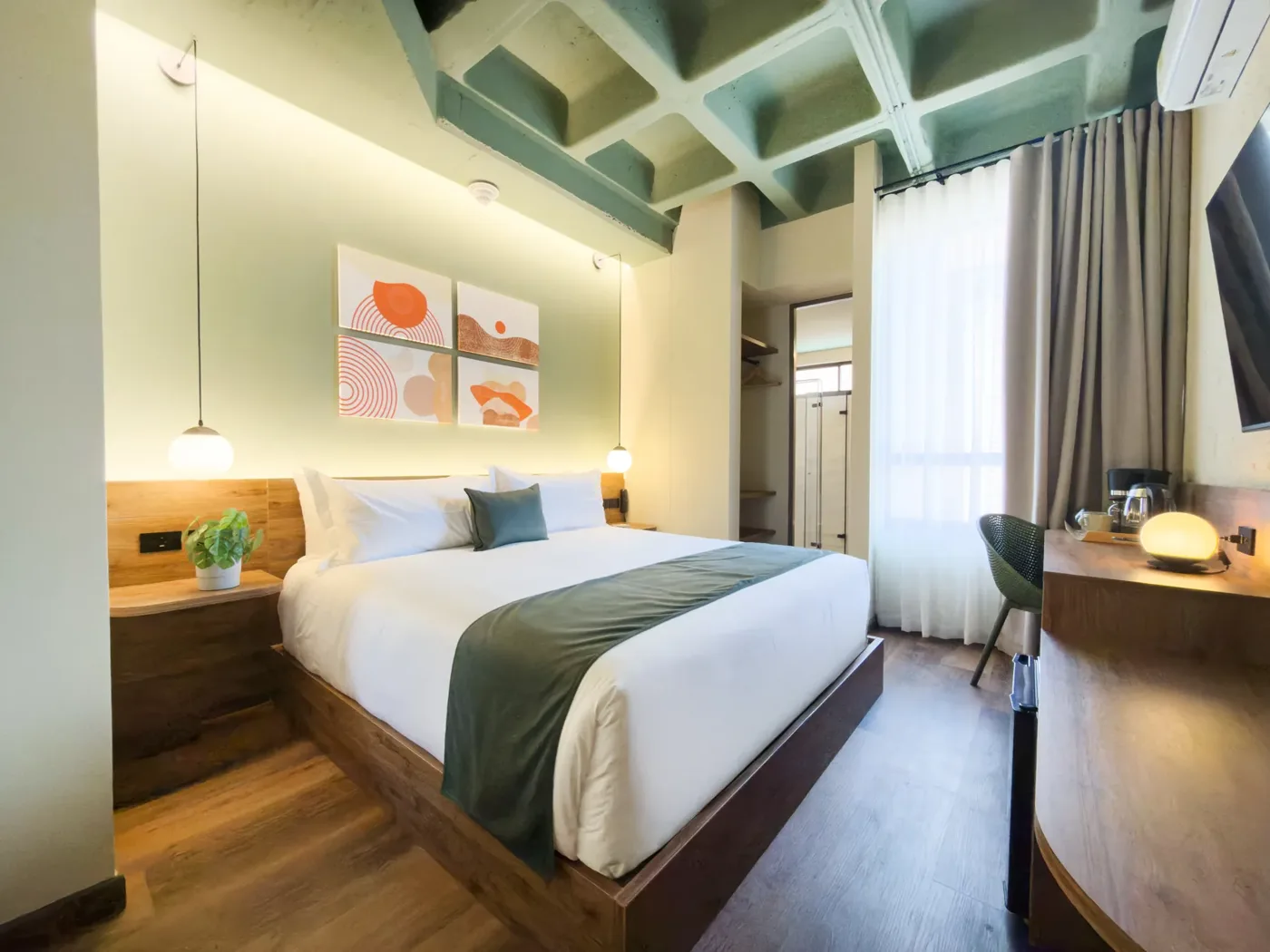 Suite Estándar con cama king, techo de vigas verdes y cuadros