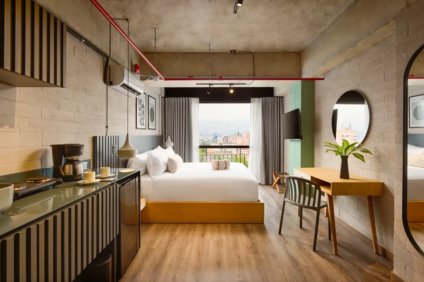 Suite Deluxe con cama, cafetera, escritorio y espejo redondo