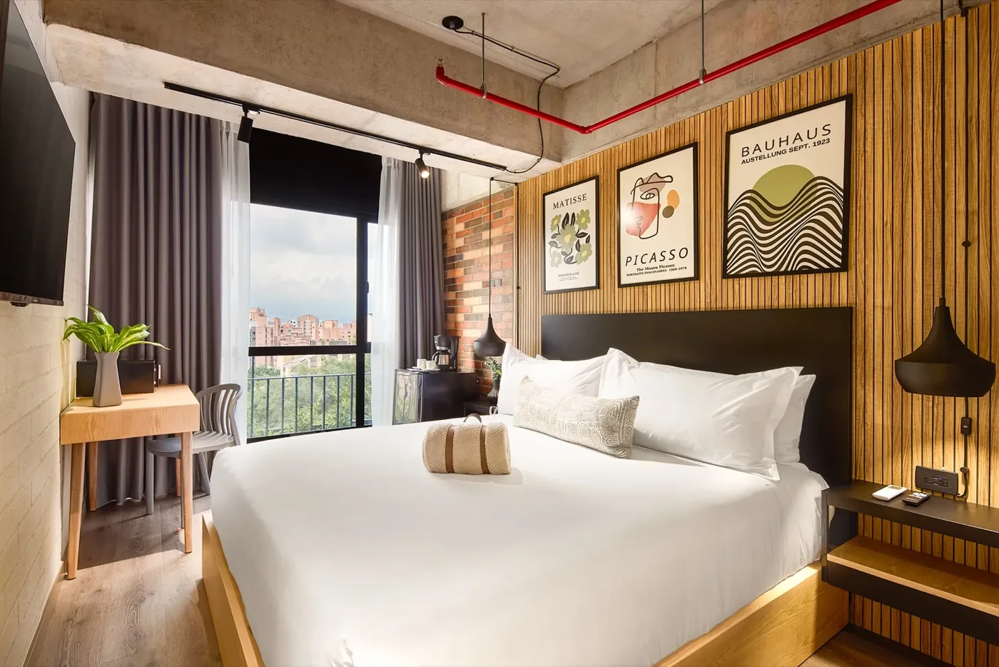 Suite Ejecutiva con cabecero de madera y cuadros sobre la cama