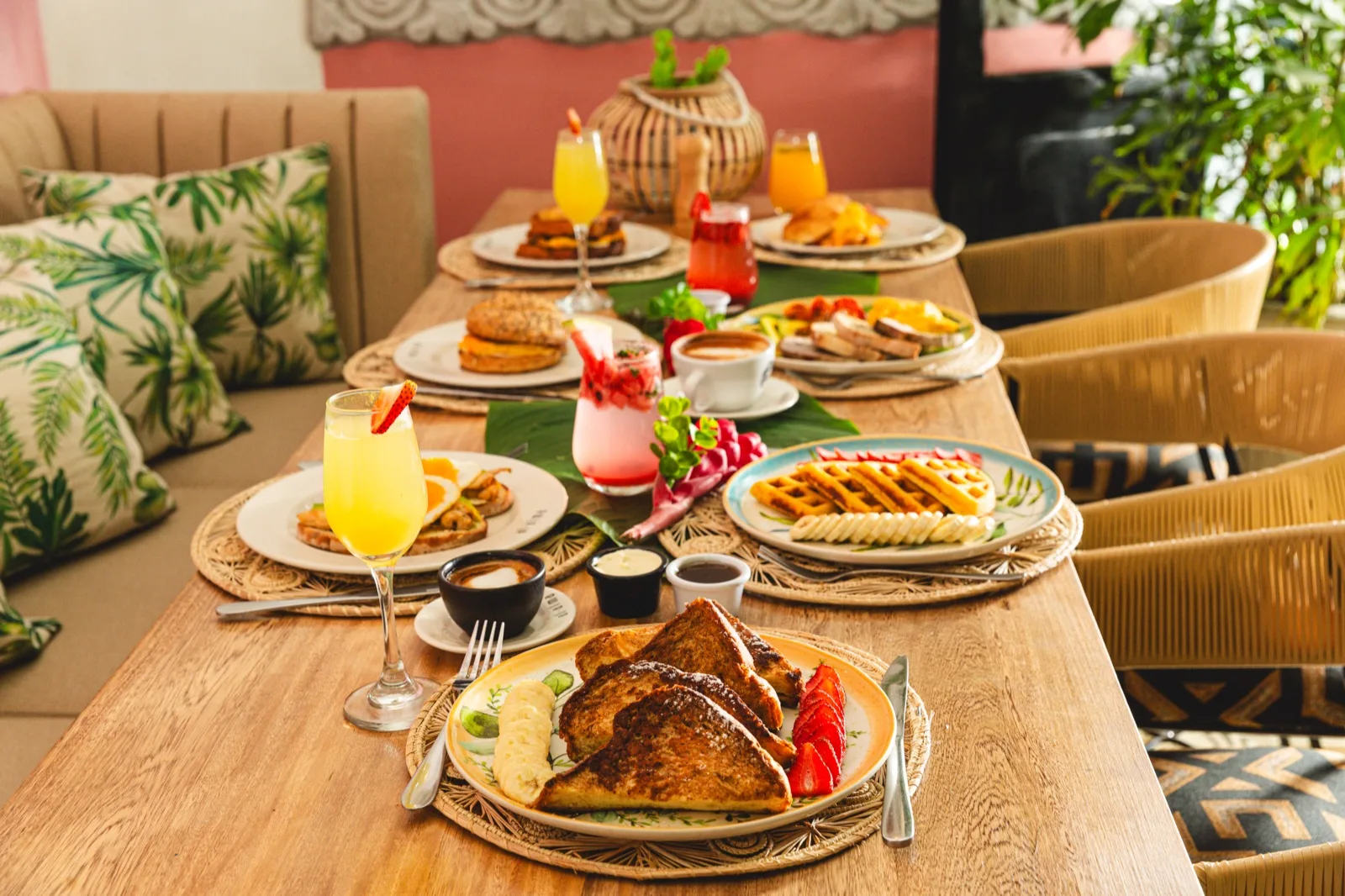 Mesa de brunch con tostadas francesas, waffles y jugos en Al Alma
