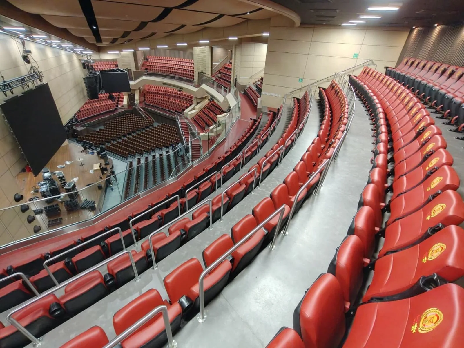 Tribunas de sillas rojas de la Arena USC vistas desde lo alto, con el escenario al fondo
