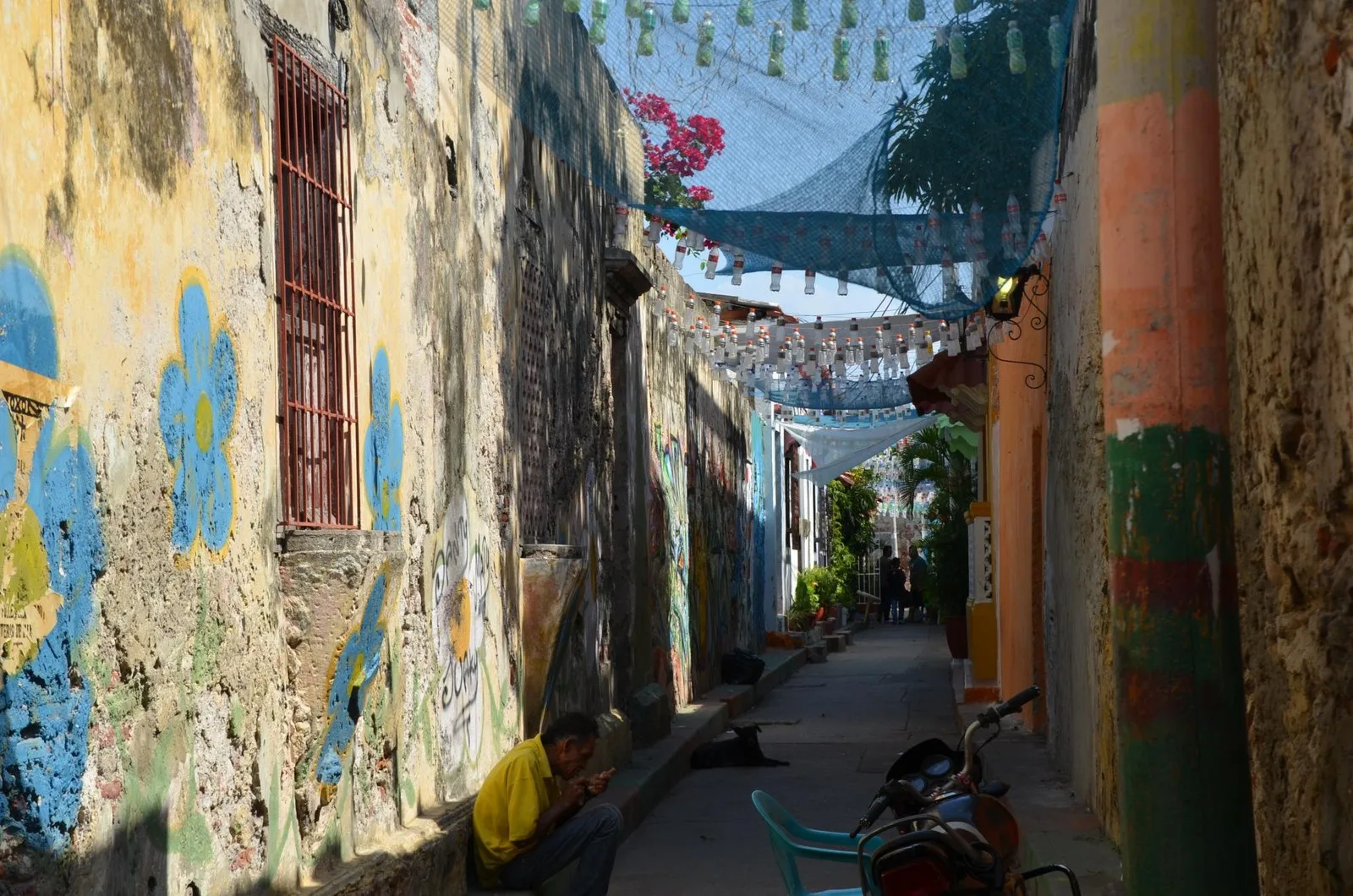 Callejón angosto de Getsemaní con paredes pintadas y banderines arriba