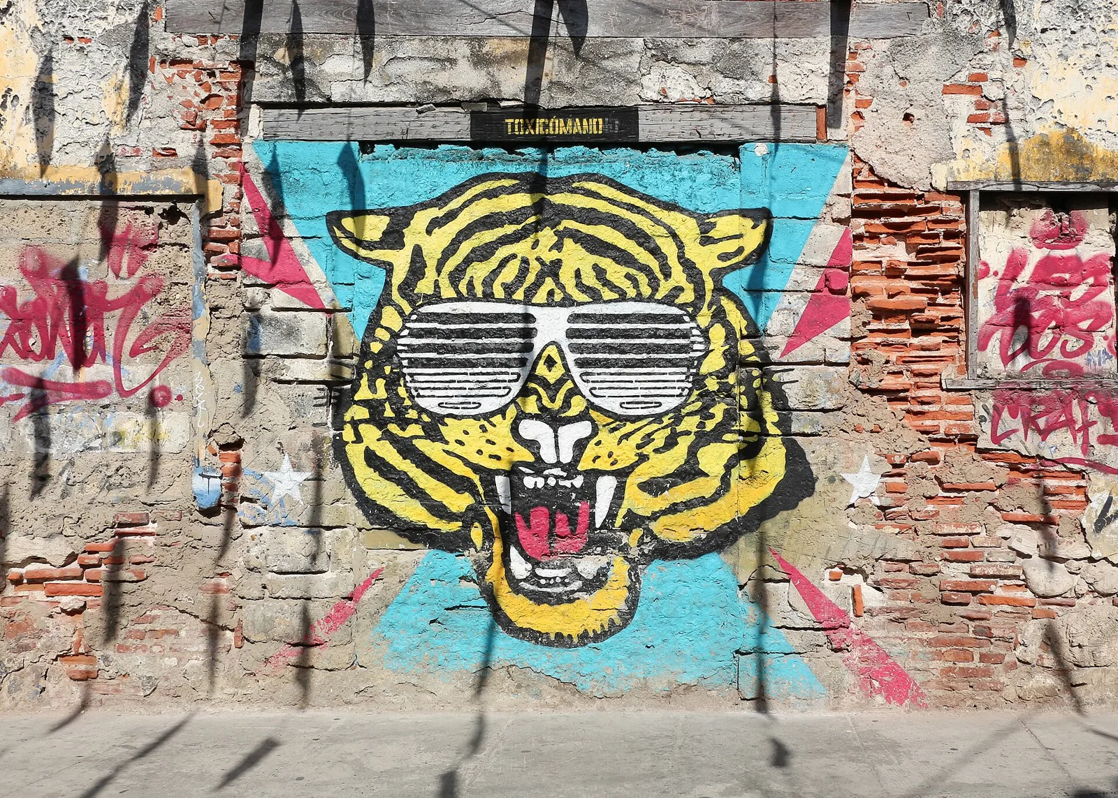 Mural de un tigre con gafas sobre una pared de ladrillo en Getsemaní