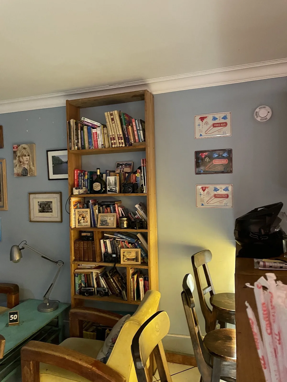 Zona de lectura de Café Cliché con biblioteca y sillas de colores