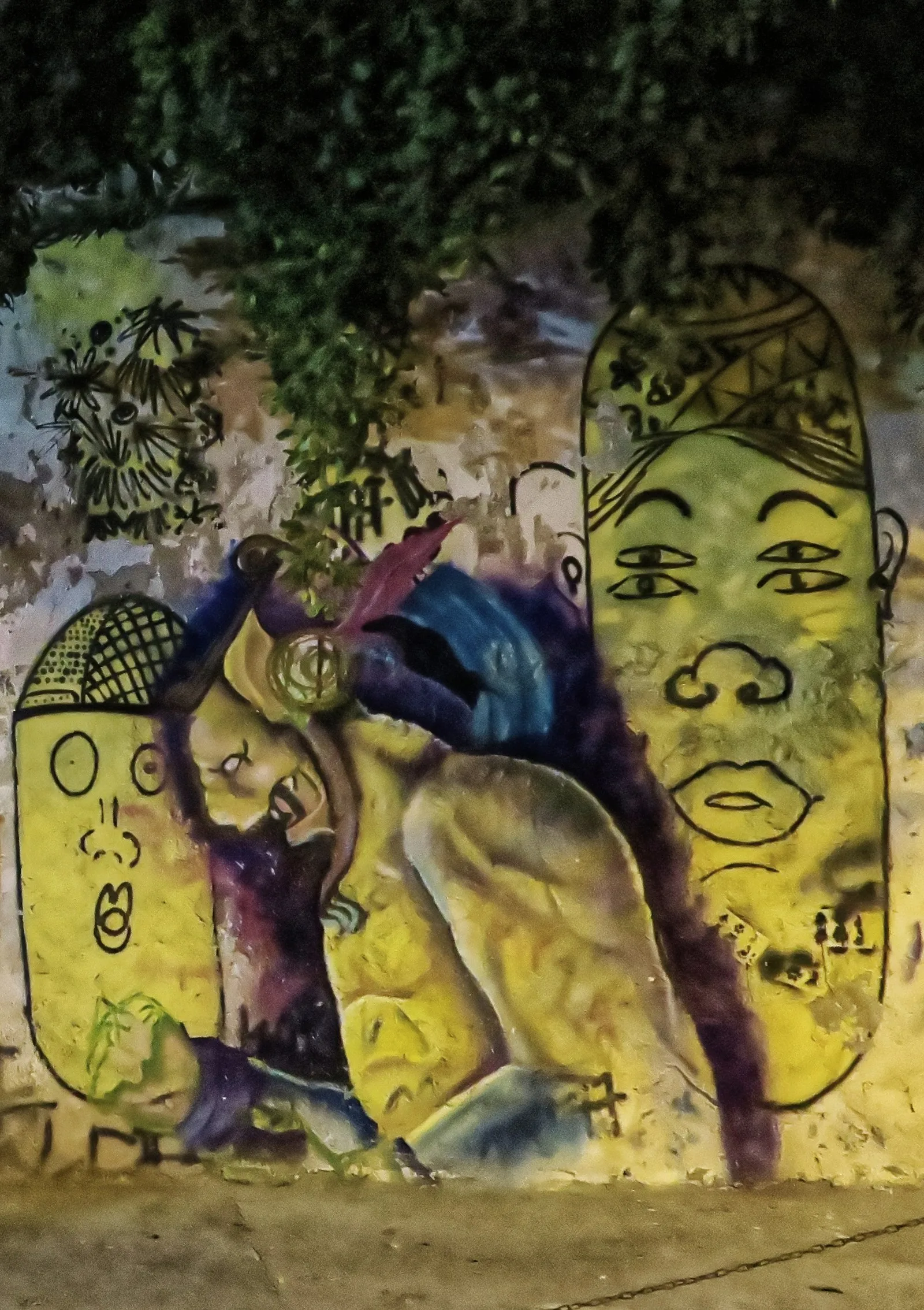 Mural de rostros entre plantas colgantes en el Café del Mural