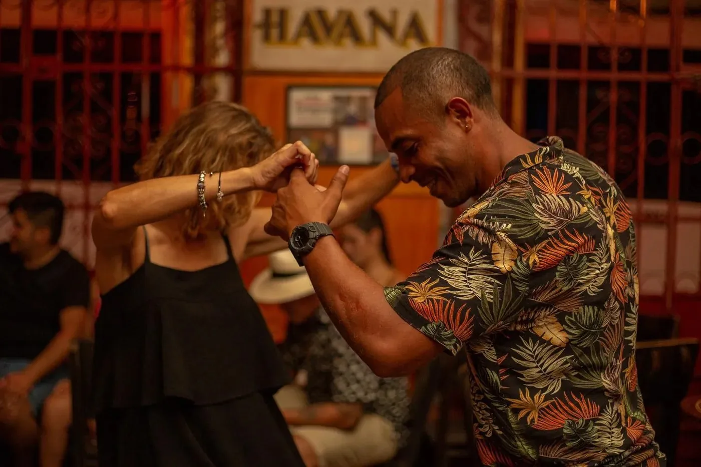 Pareja bailando salsa bajo el letrero de Café Havana