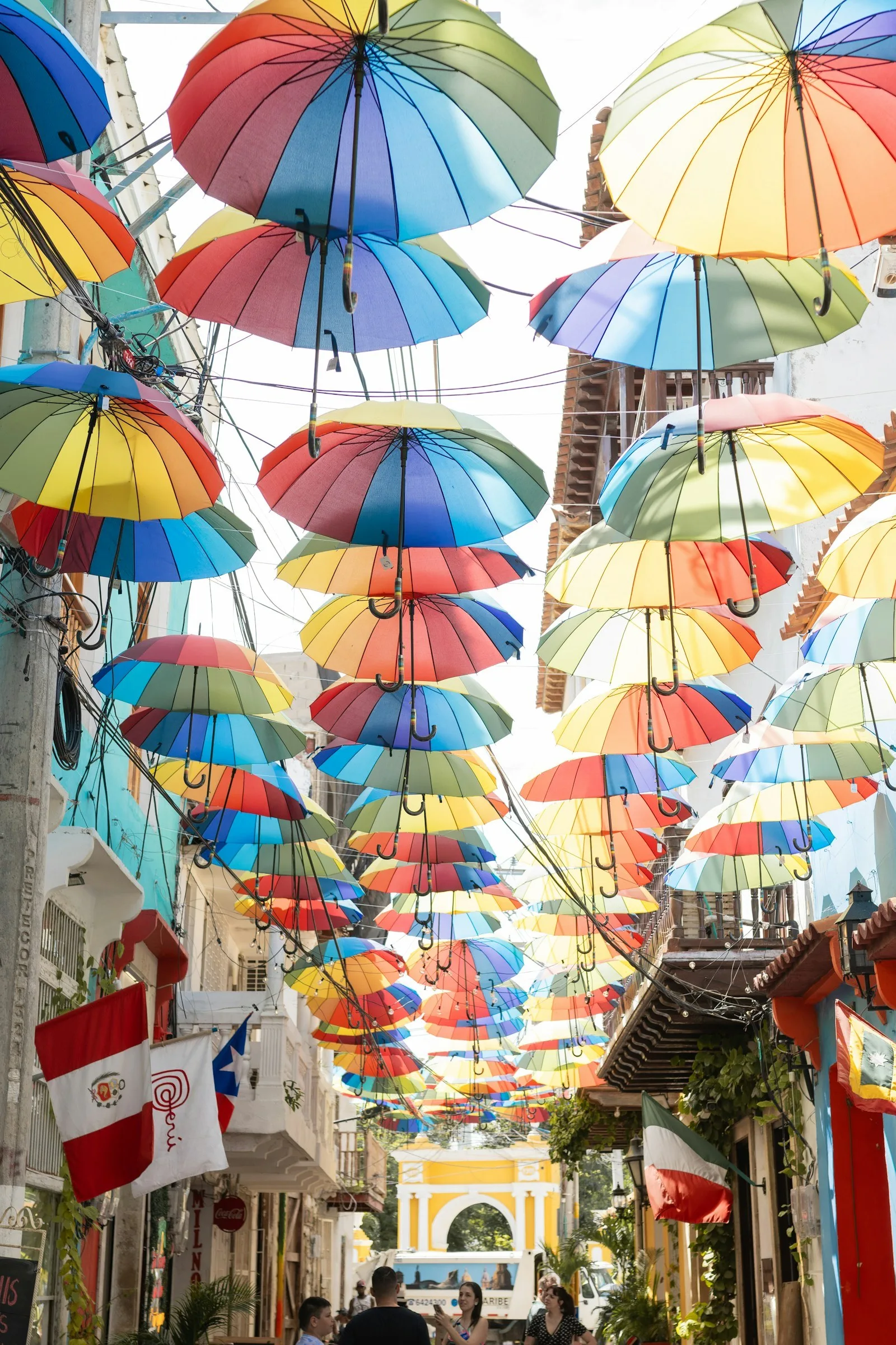Gente caminando bajo el techo de sombrillas de colores en Getsemaní