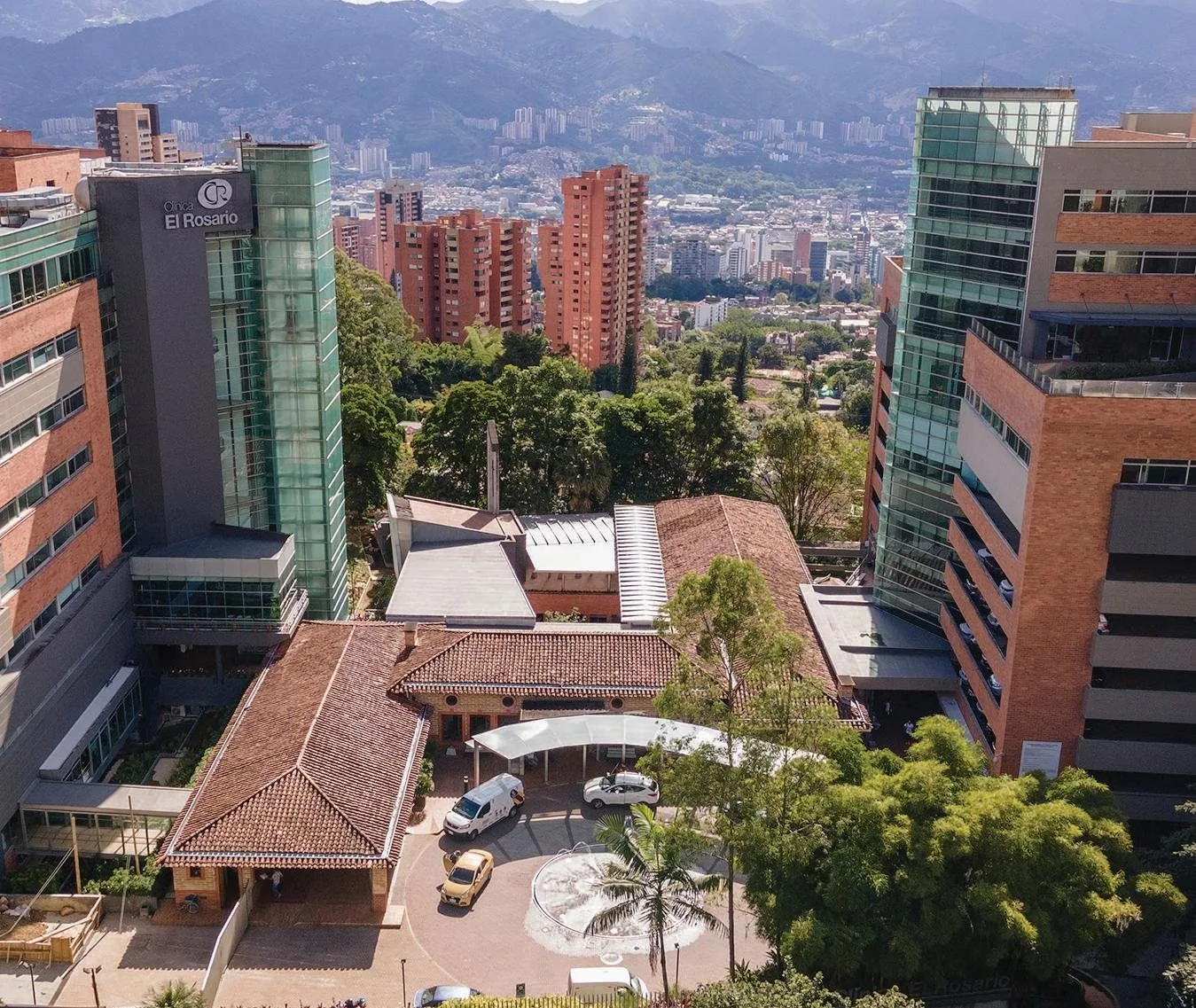 Vista aérea de la Clínica El Rosario sede El Tesoro, con El Poblado y las montañas al fondo