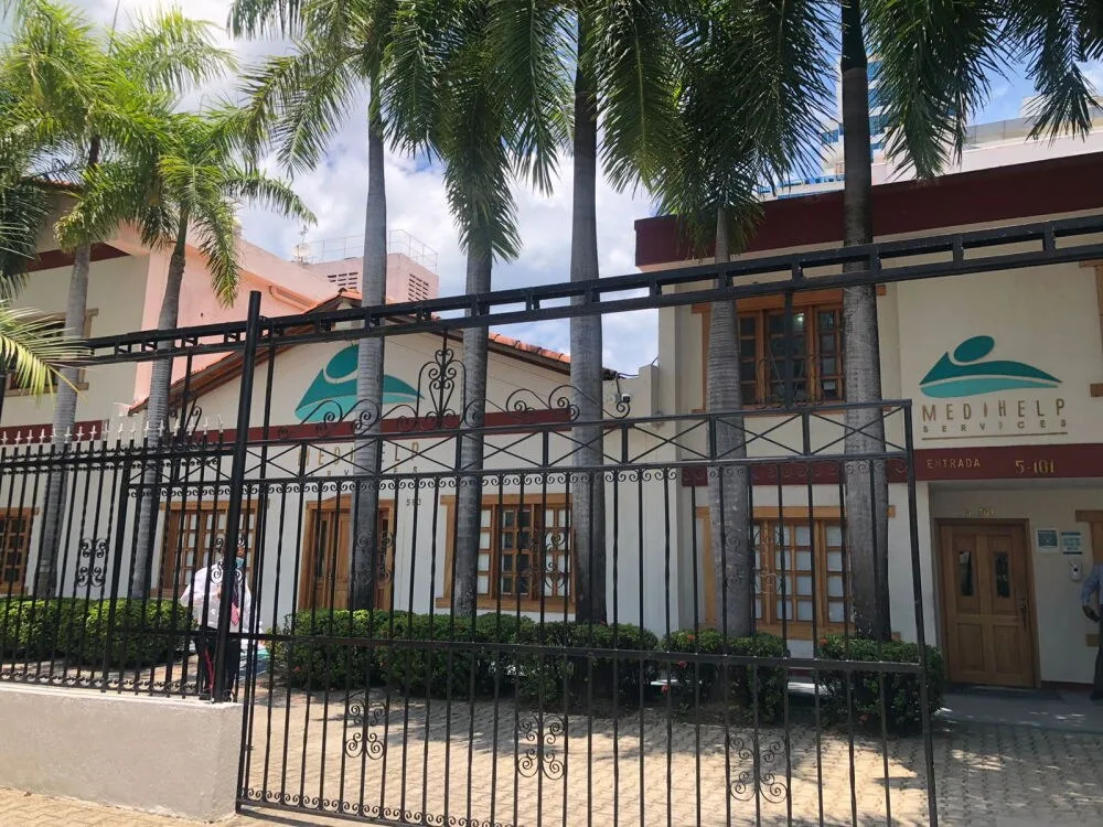 Entrada de la Clínica Medihelp en Bocagrande, con su reja y palmas al frente