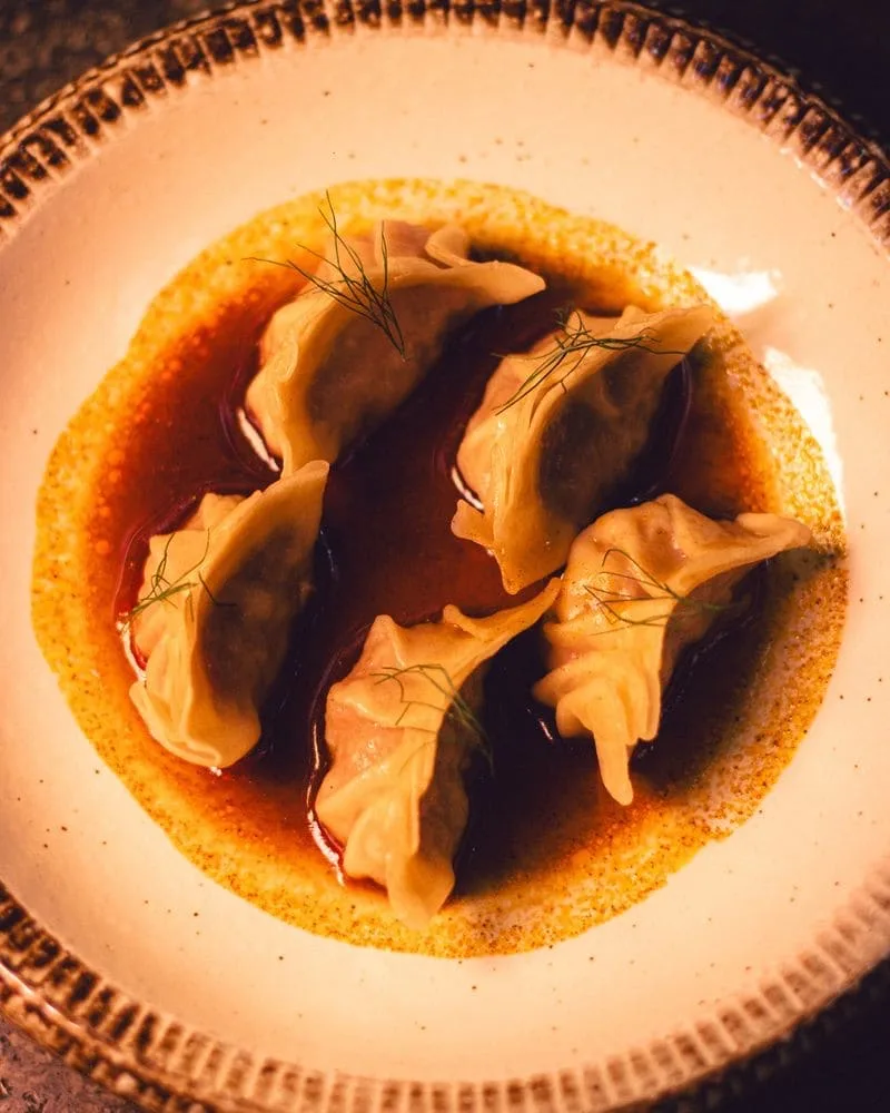 Gyozas en salsa servidas en plato de cerámica en Cuon