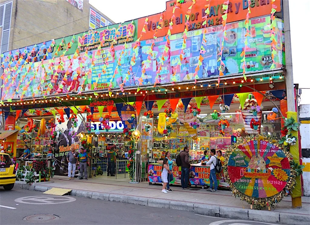 Fachada de un almacén de artículos de fiesta en El Hueco, llena de banderines y adornos de colores