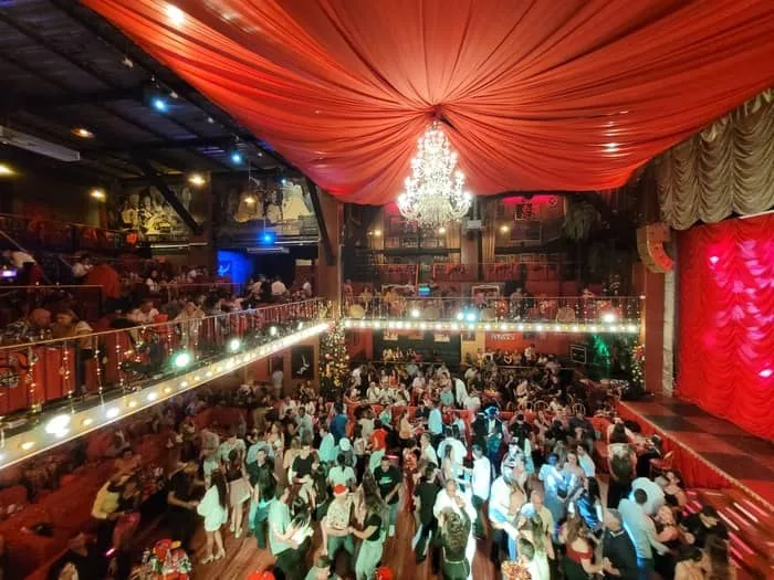 Sala de El Mulato Cabaret llena de gente bailando bajo una lámpara de cristal