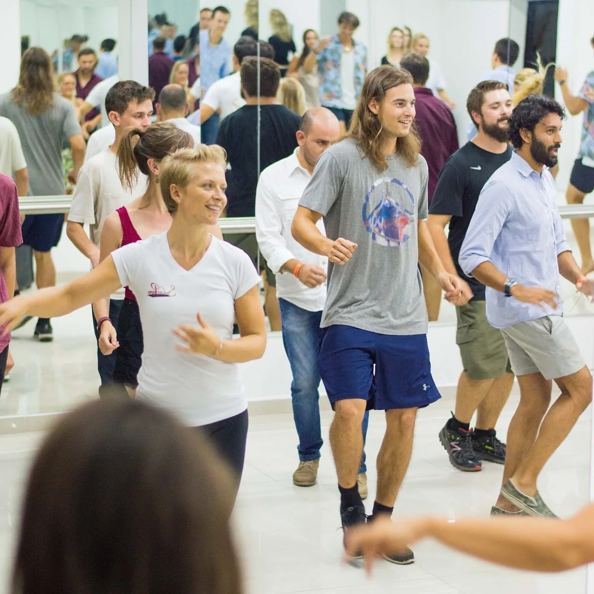 Clase grupal de salsa en el salón de espejos de Salsa Pura
