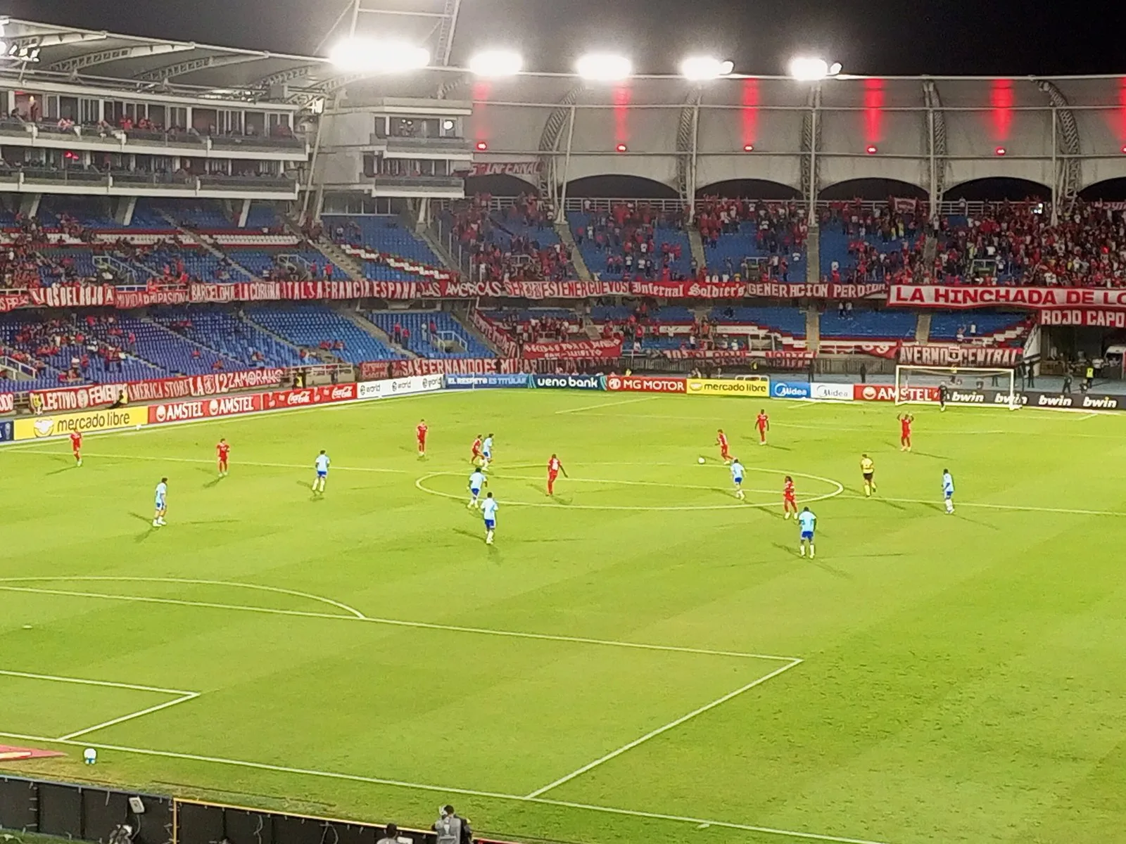 Partido nocturno del América de Cali en el Pascual Guerrero, con la tribuna llena de hinchas de rojo