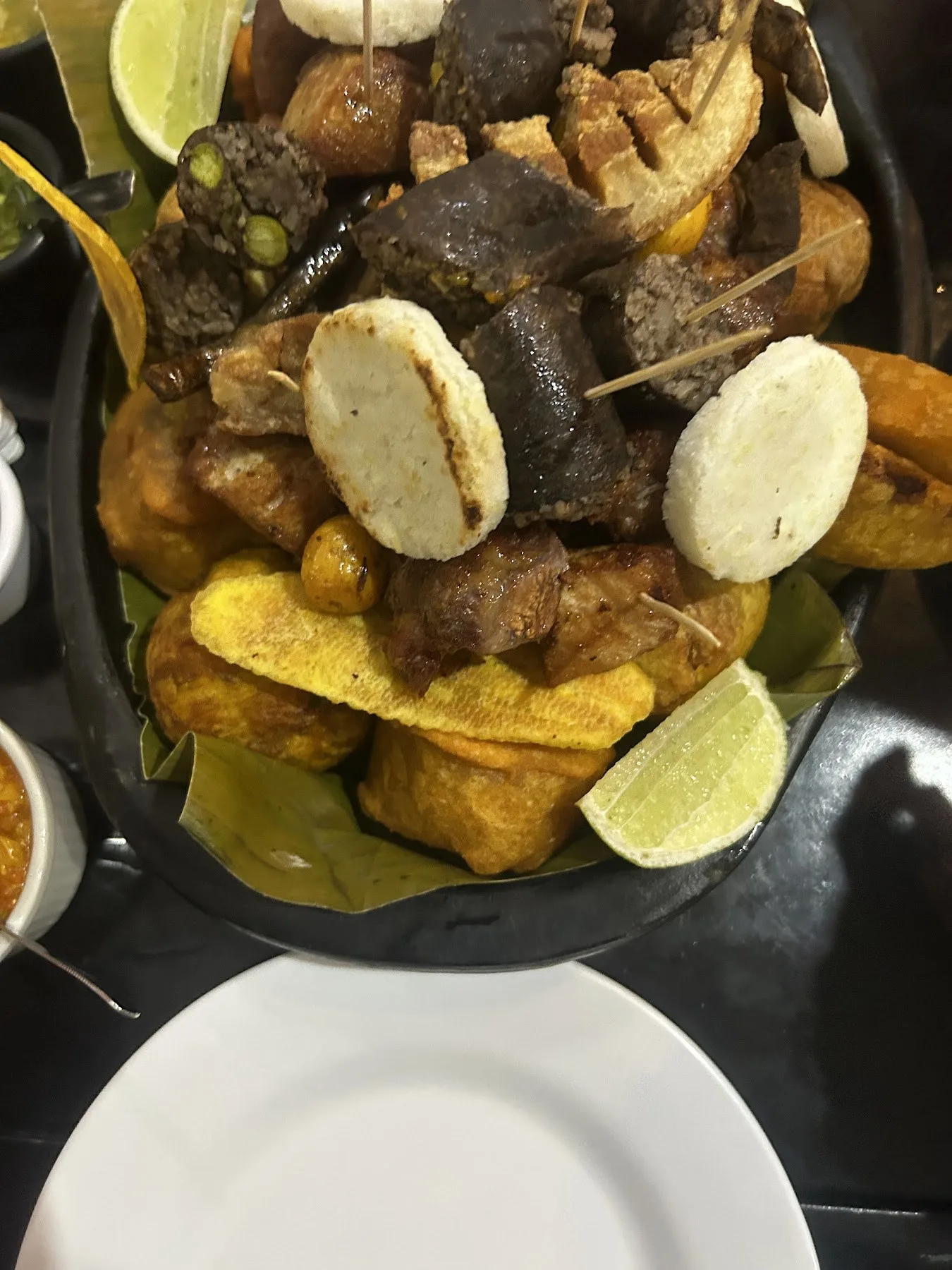 Picada valluna con chicharrón, arepa, maduro y limón en Fritanga J&J