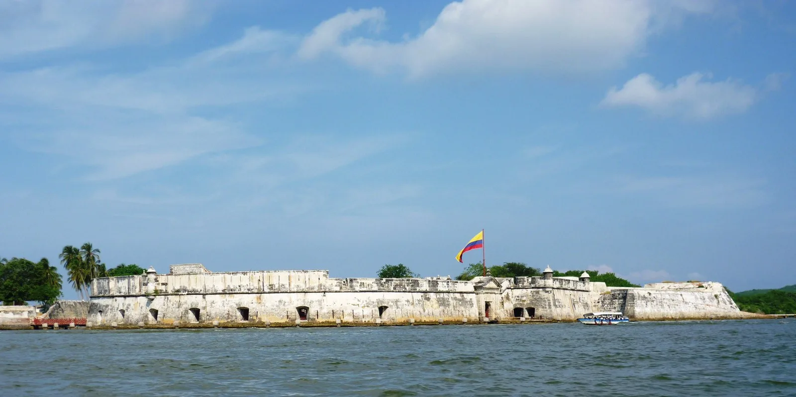 Muralla blanca del fuerte a ras del agua en la entrada de la bahía