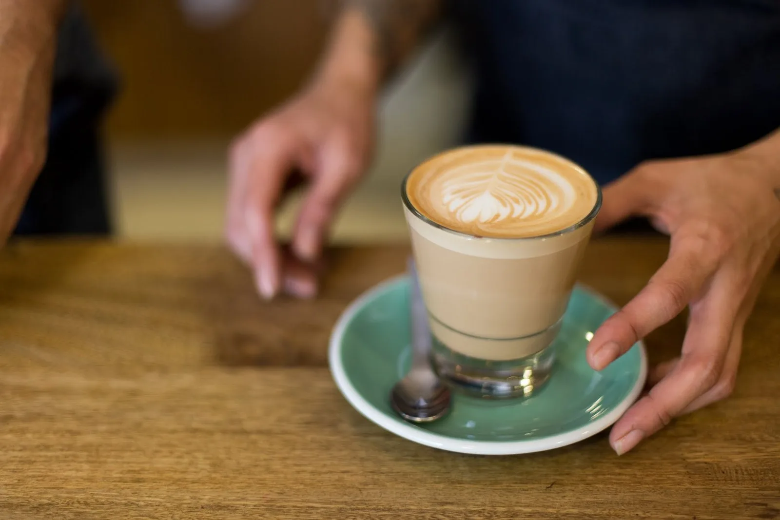 Café con leche en vaso de vidrio servido en la barra de Hija Mía