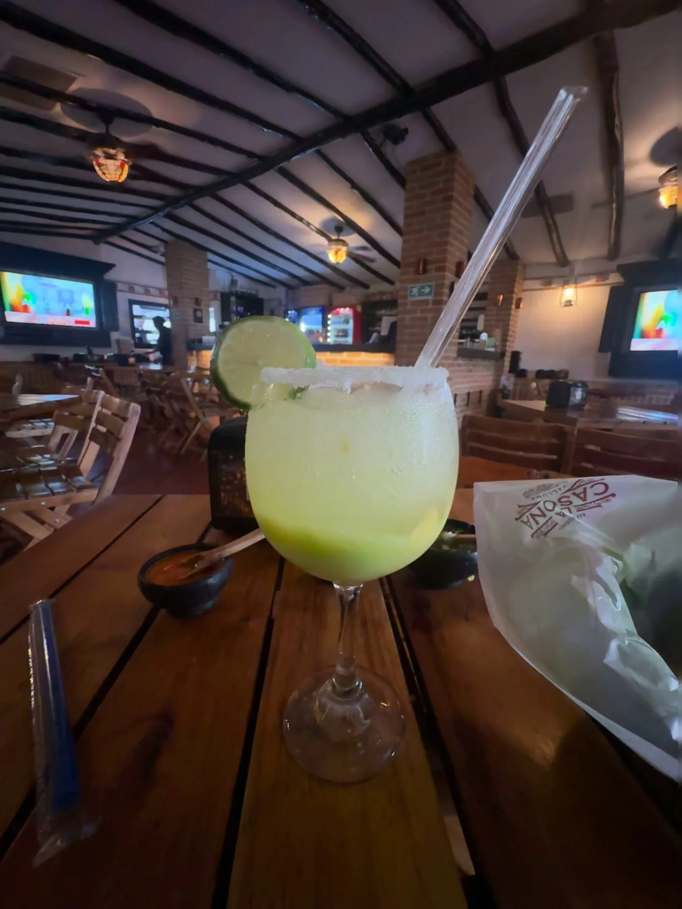 Bebida fría en copa escarchada con el salón de La Casona Valluna al fondo