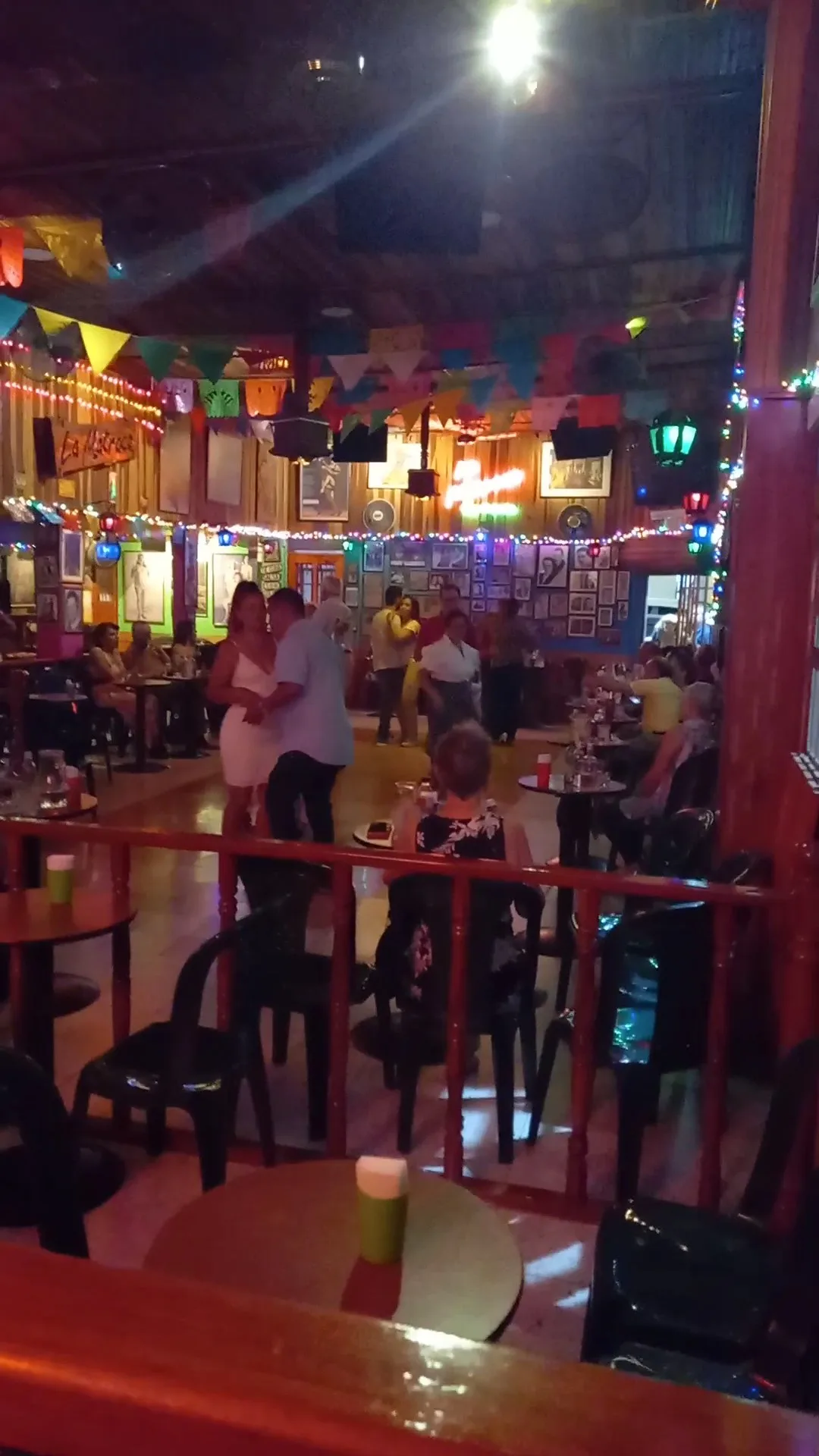 Pista de La Matraca con parejas bailando y paredes llenas de fotos de tango