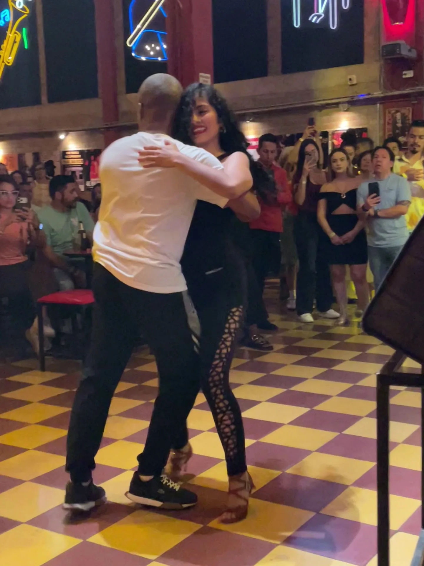 Pareja bailando salsa en la pista ajedrezada de La Topa Tolondra
