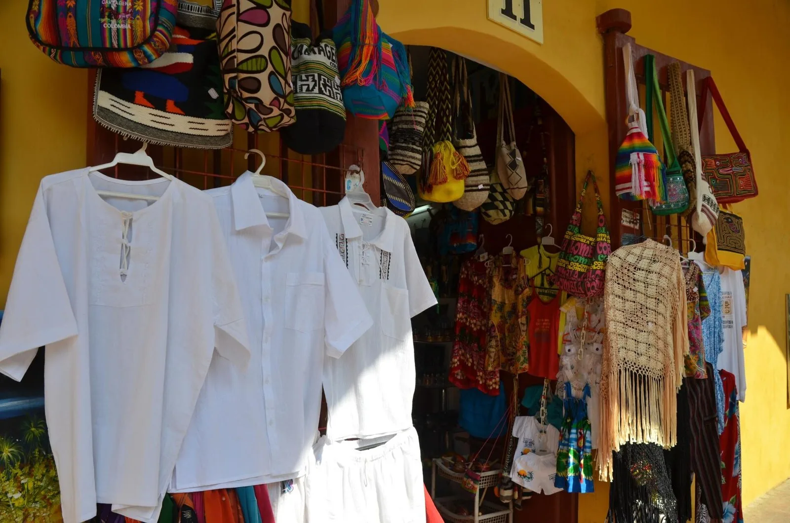 Artesanías, mochilas y camisas de lino en un local de Las Bóvedas