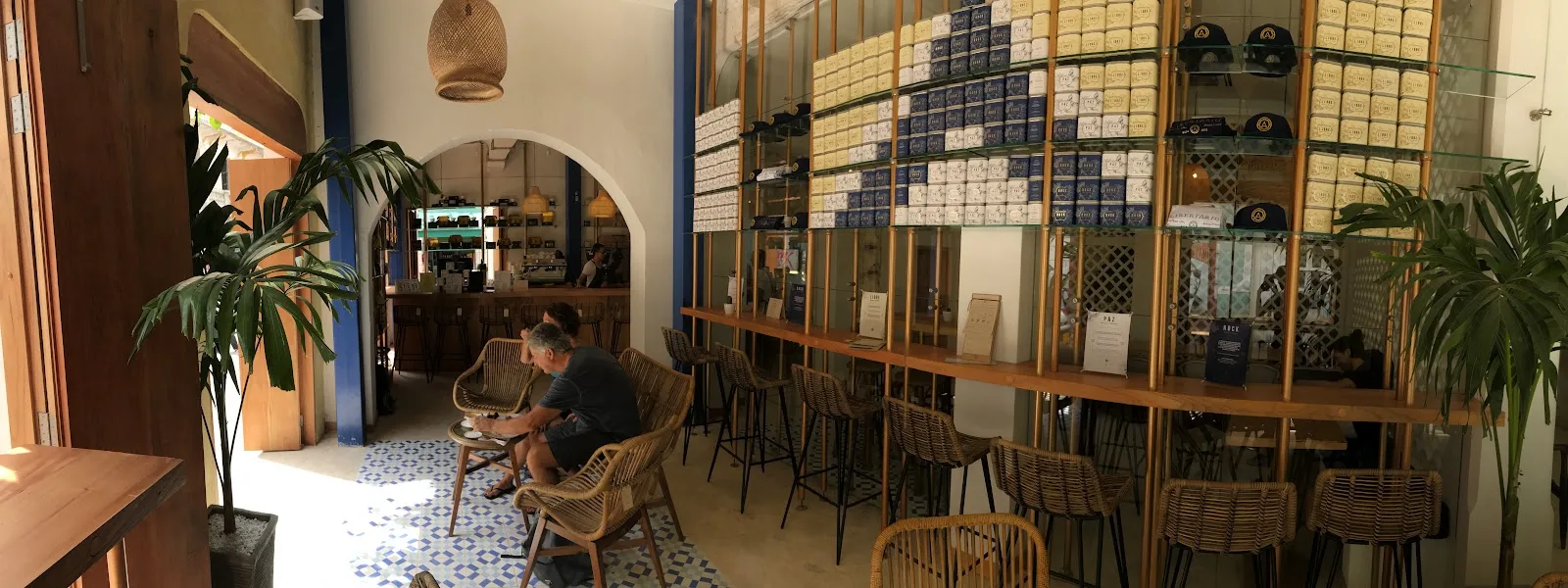 Mesas y estantes con plantas dentro de Libertario Coffee Roasters