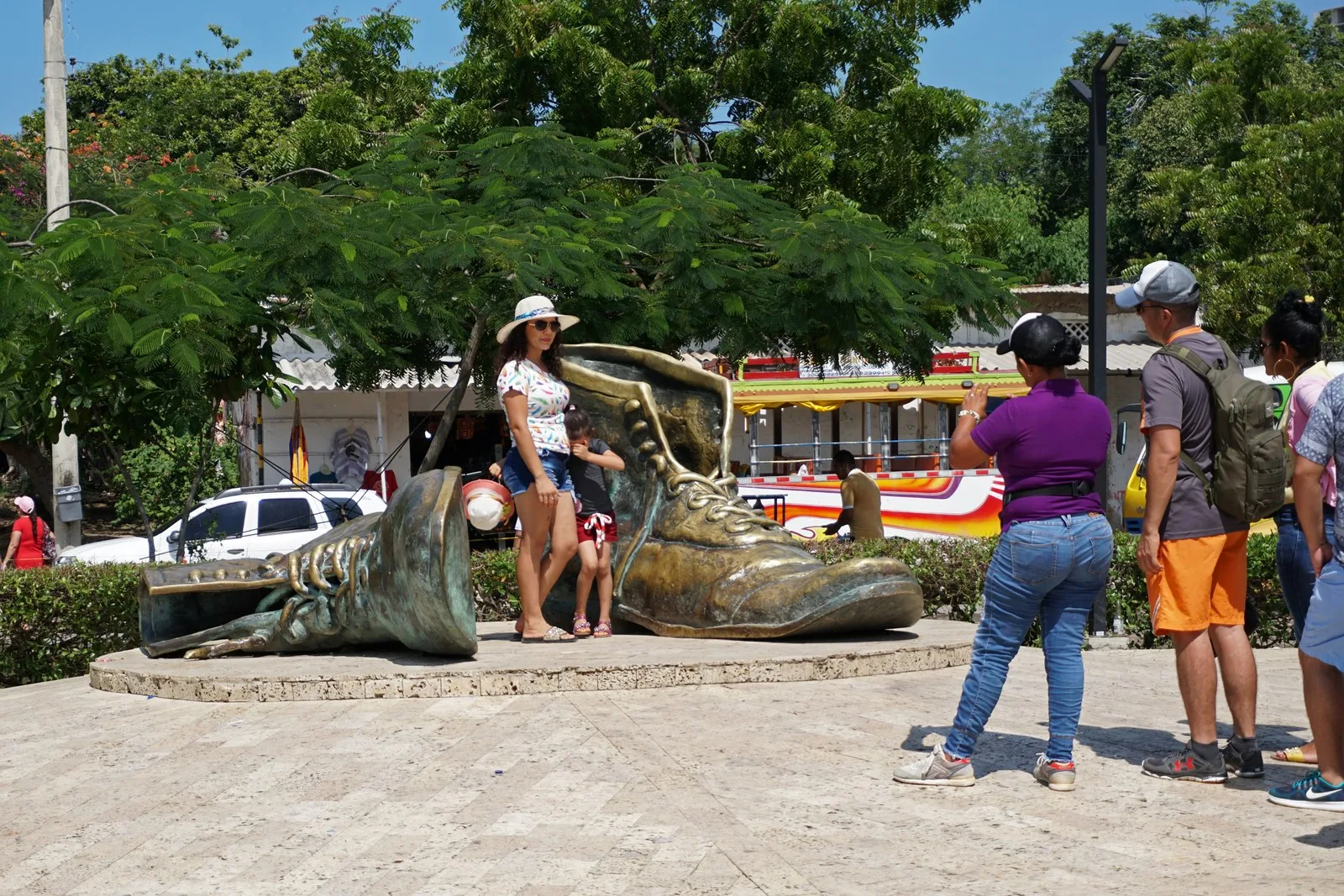 Visitantes tomándose fotos junto a los Zapatos Viejos