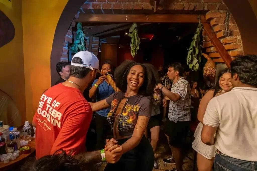 Parejas bailando salsa en MalaMaña con percusionista al fondo