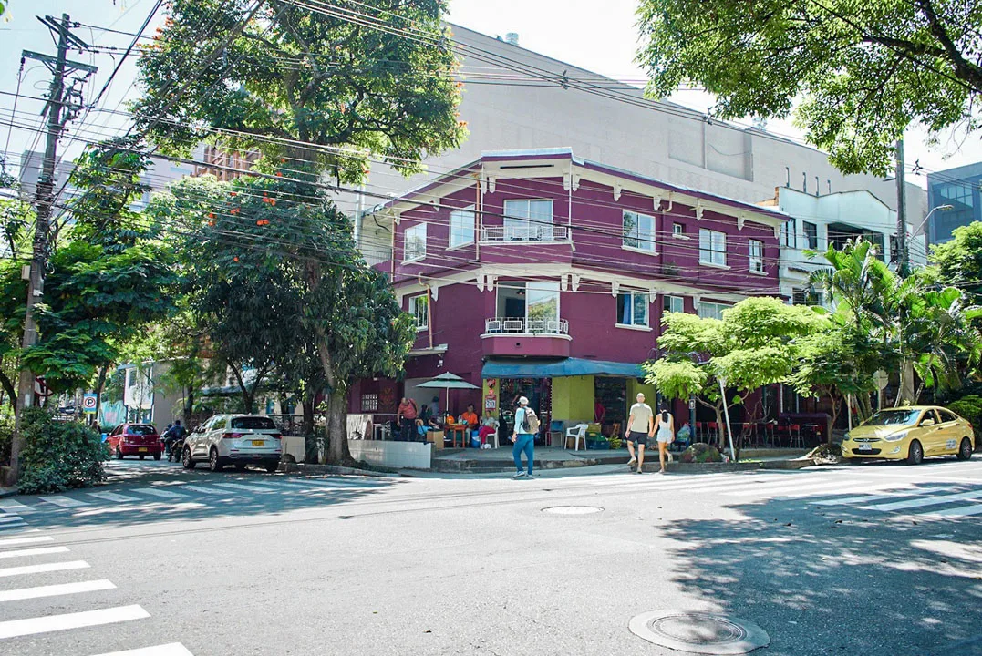 Esquina de Manila con una casa vieja pintada y mesas de café en la acera