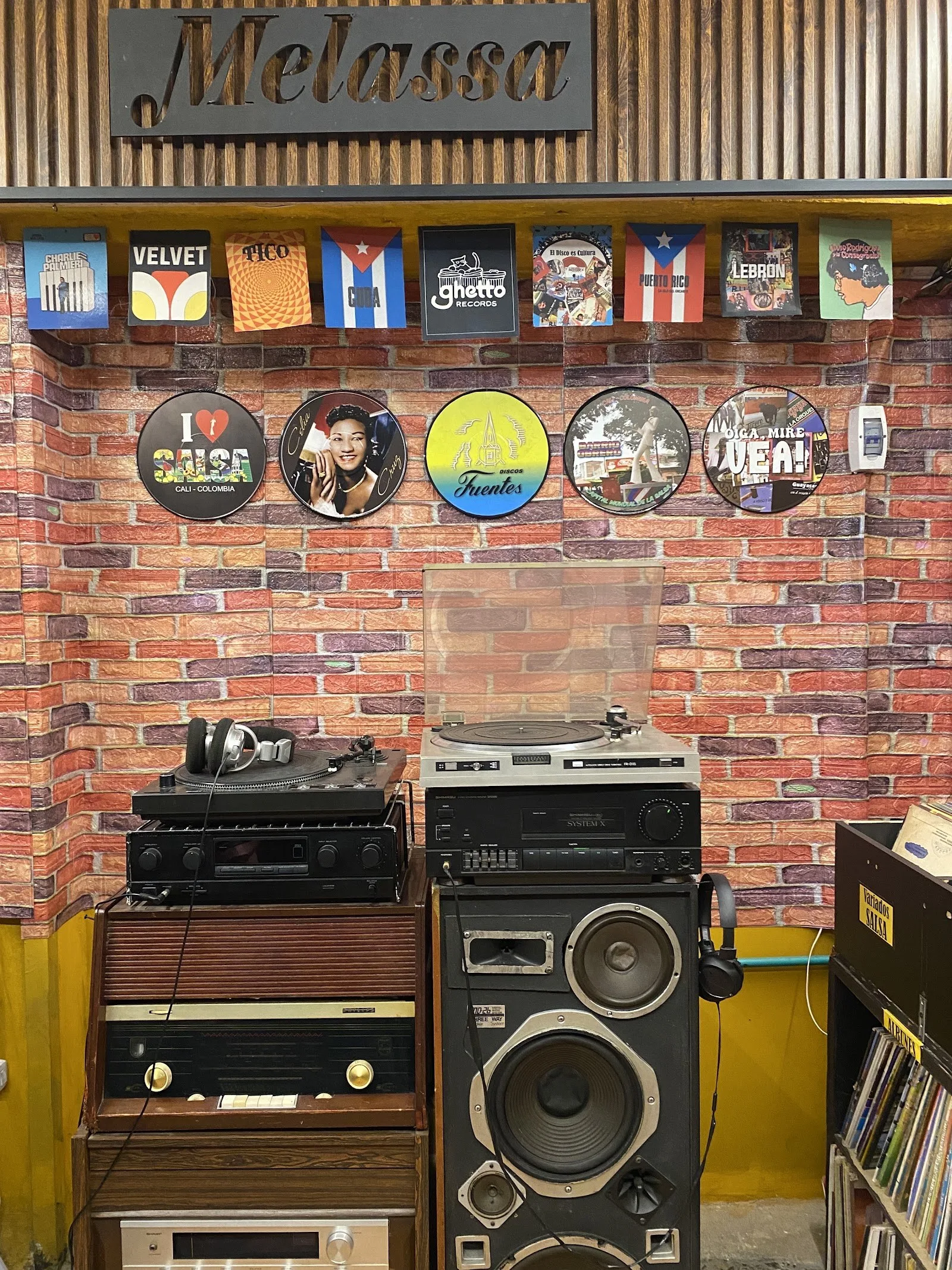 Tornamesas y equipos de sonido antiguos bajo el letrero de Melassa