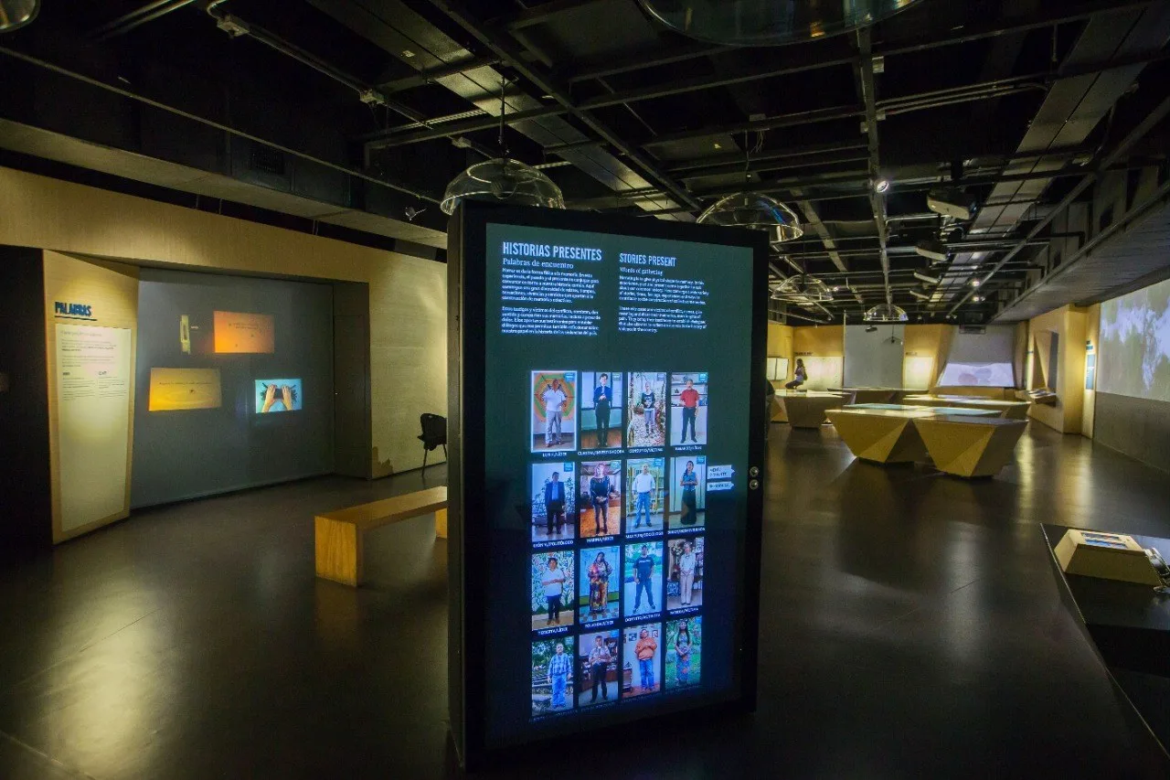 Sala central del museo con pantallas de historias de víctimas