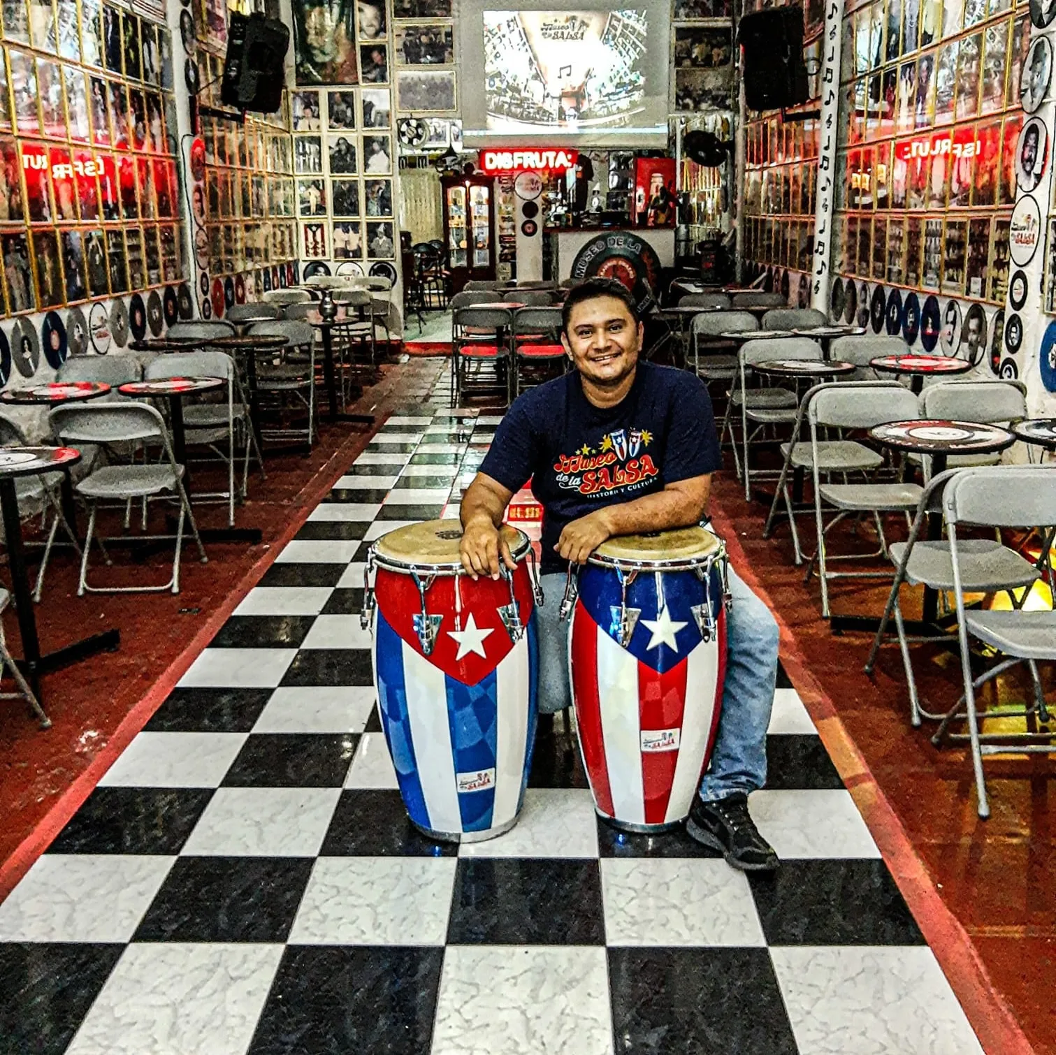 Salón del Museo de la Salsa, con piso de ajedrez, congas y paredes llenas de fotos y discos