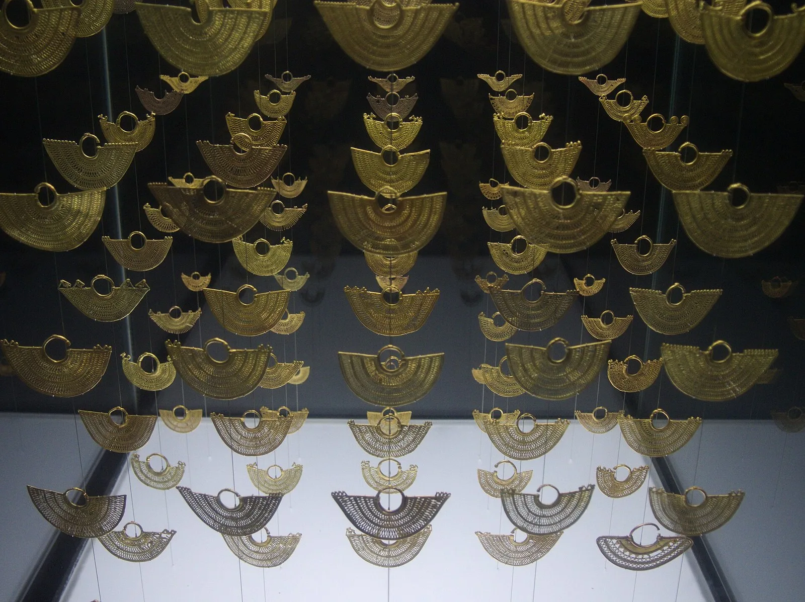 Orejeras de filigrana en oro zenú colgadas en una vitrina del museo