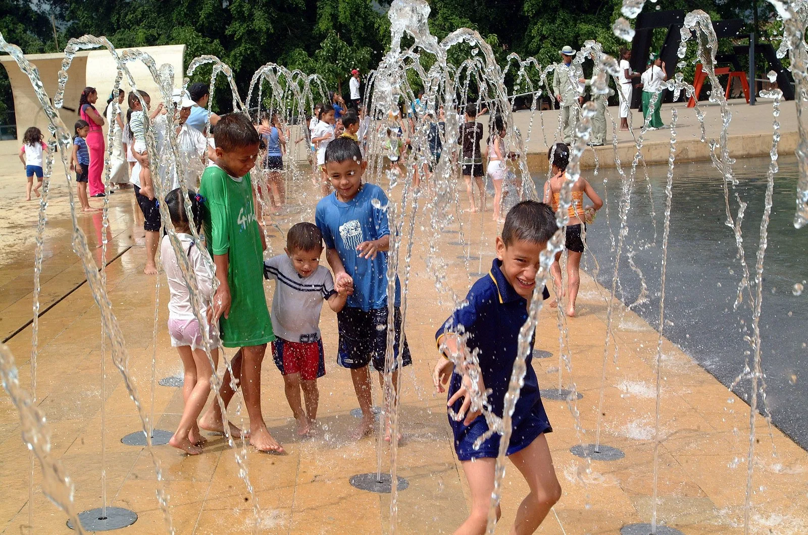 Niños jugando entre los chorros de agua del Parque de los Deseos