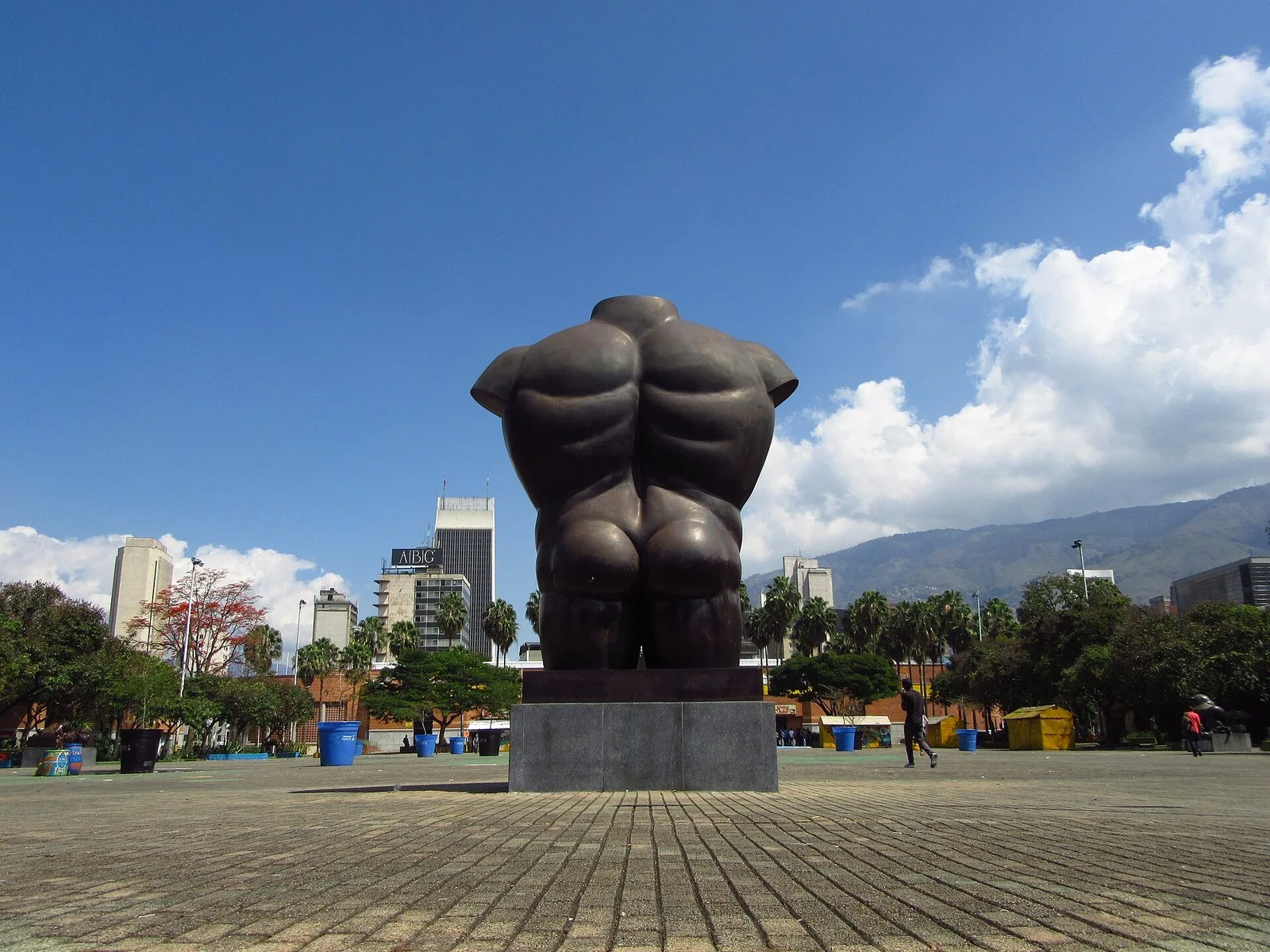 Torso masculino de bronce de Botero en la explanada del Parque San Antonio con las montañas al fondo