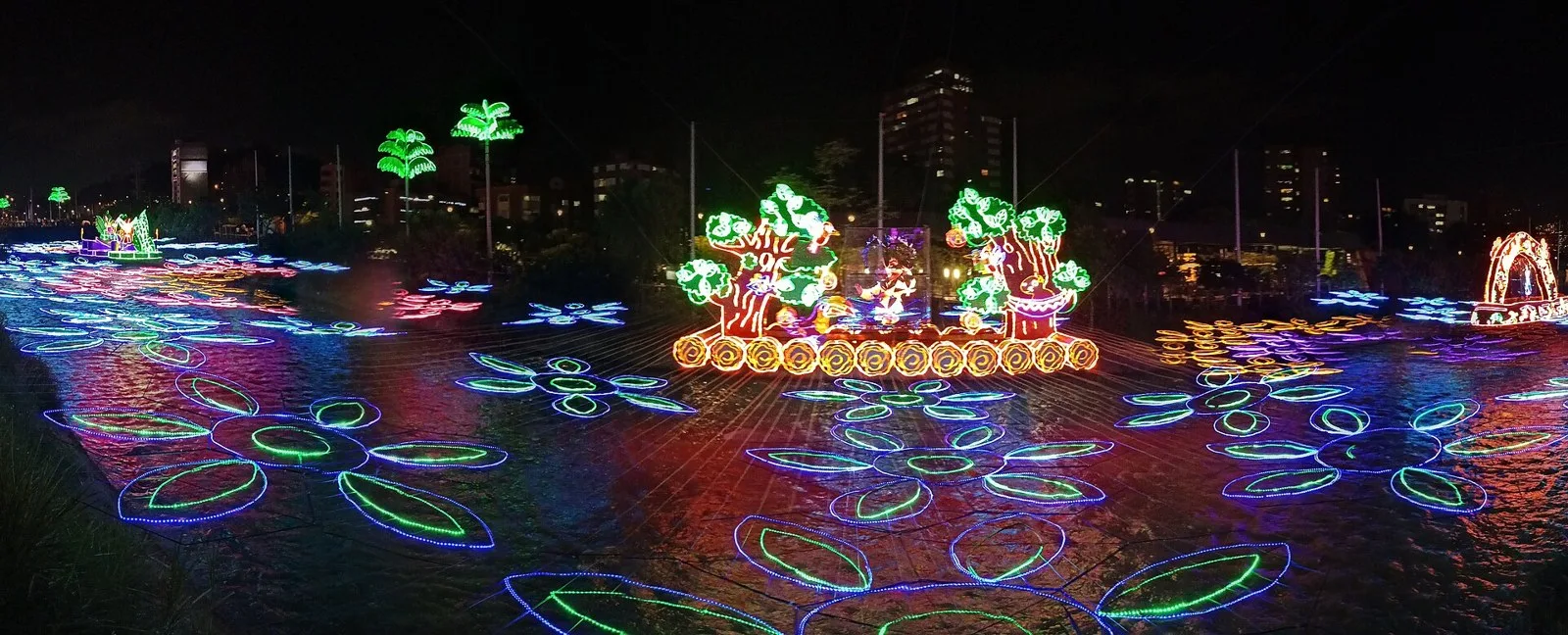 Alumbrado navideño de colores reflejado en el río Medellín, en Parques del Río