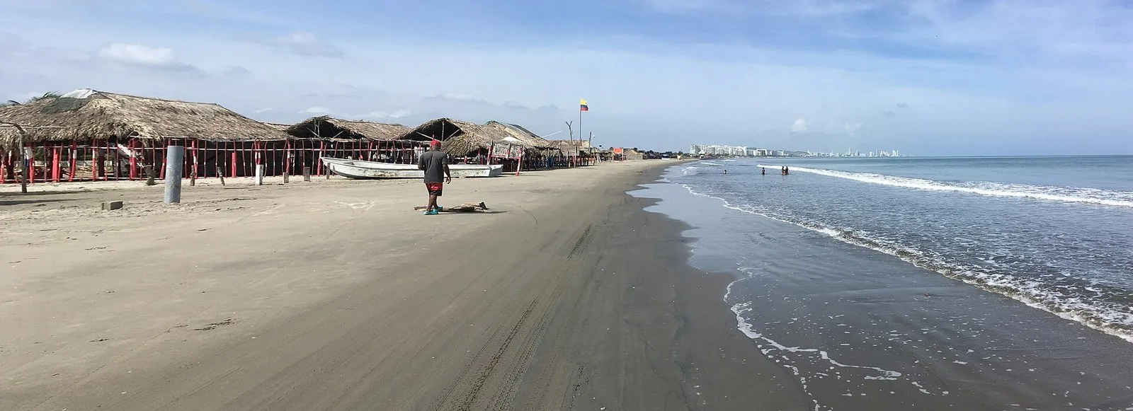 Panorámica de la playa de La Boquilla con olas y cabañas