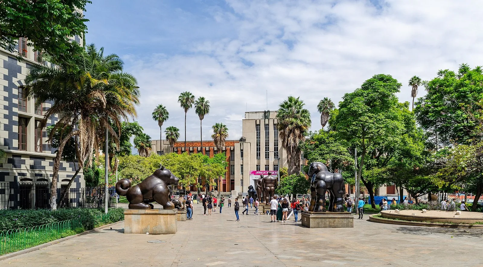 Plaza Botero con esculturas de bronce, palmeras y el Palacio de la Cultura al fondo