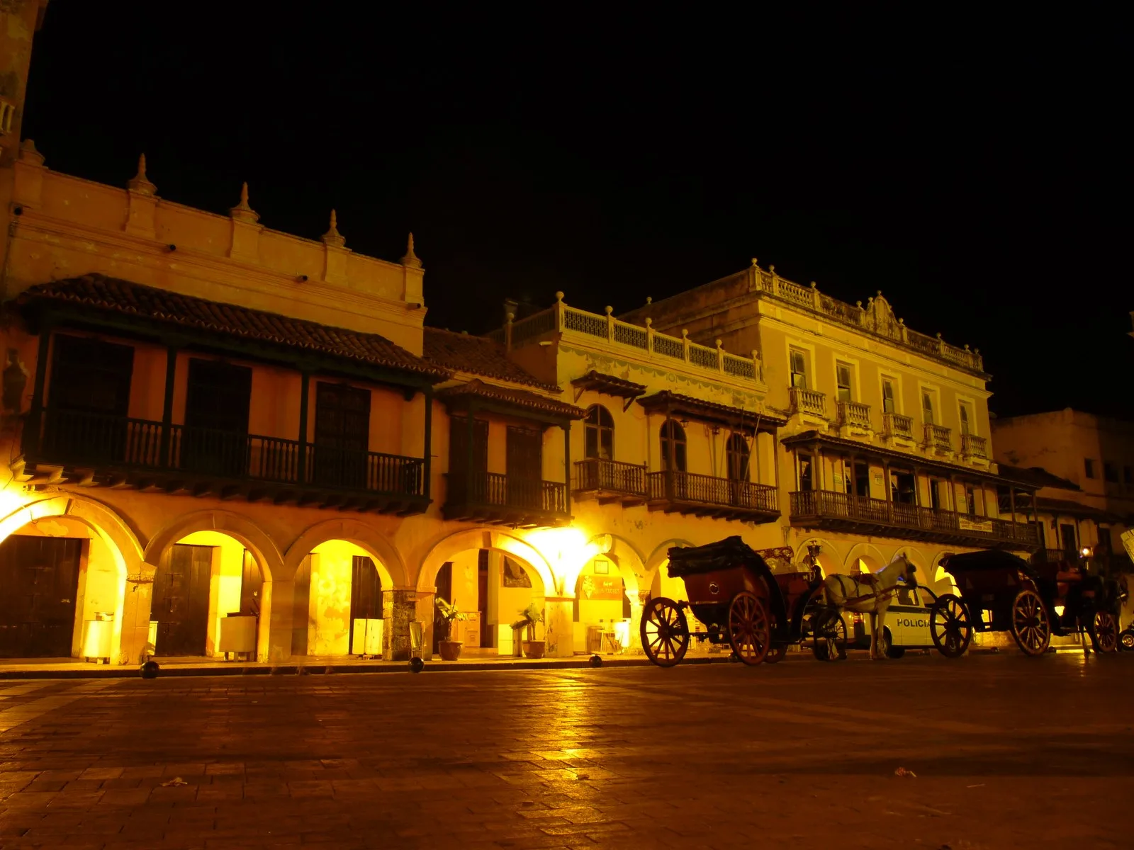 El portal de arcos iluminado de noche en la Plaza de los Coches